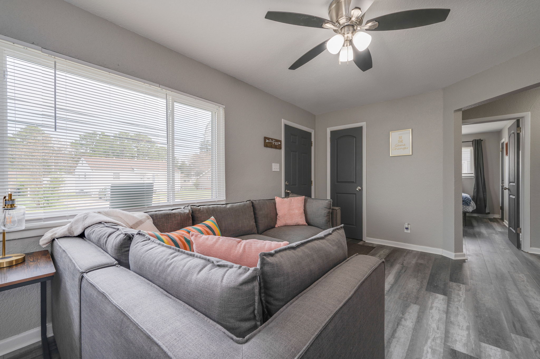 Spacious living area with gray sectional sofa and dining table