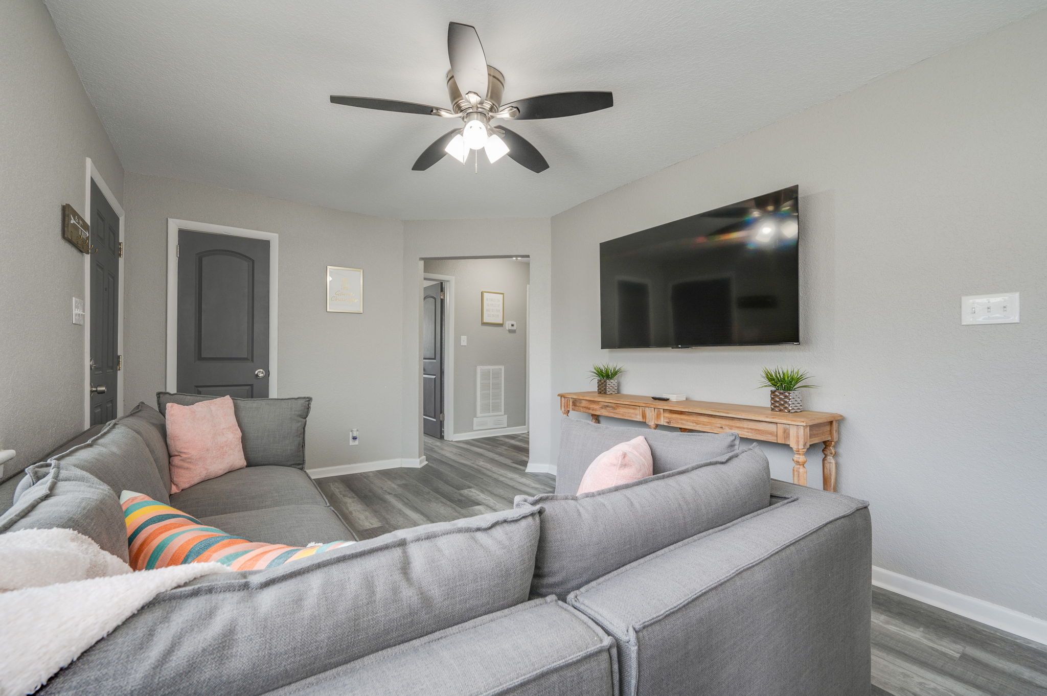 Contemporary living room with ceiling fan and gray decor