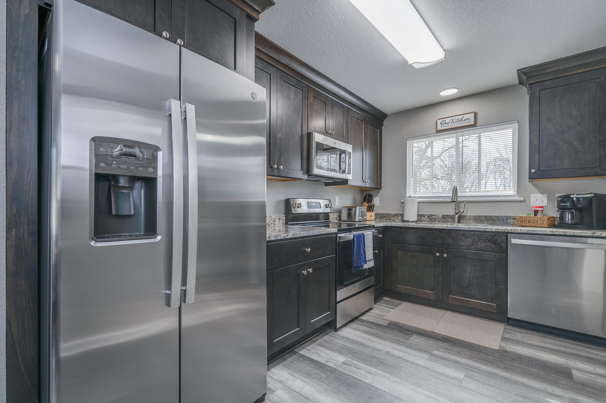 Stylish kitchen with stainless steel appliances and dark cabinets