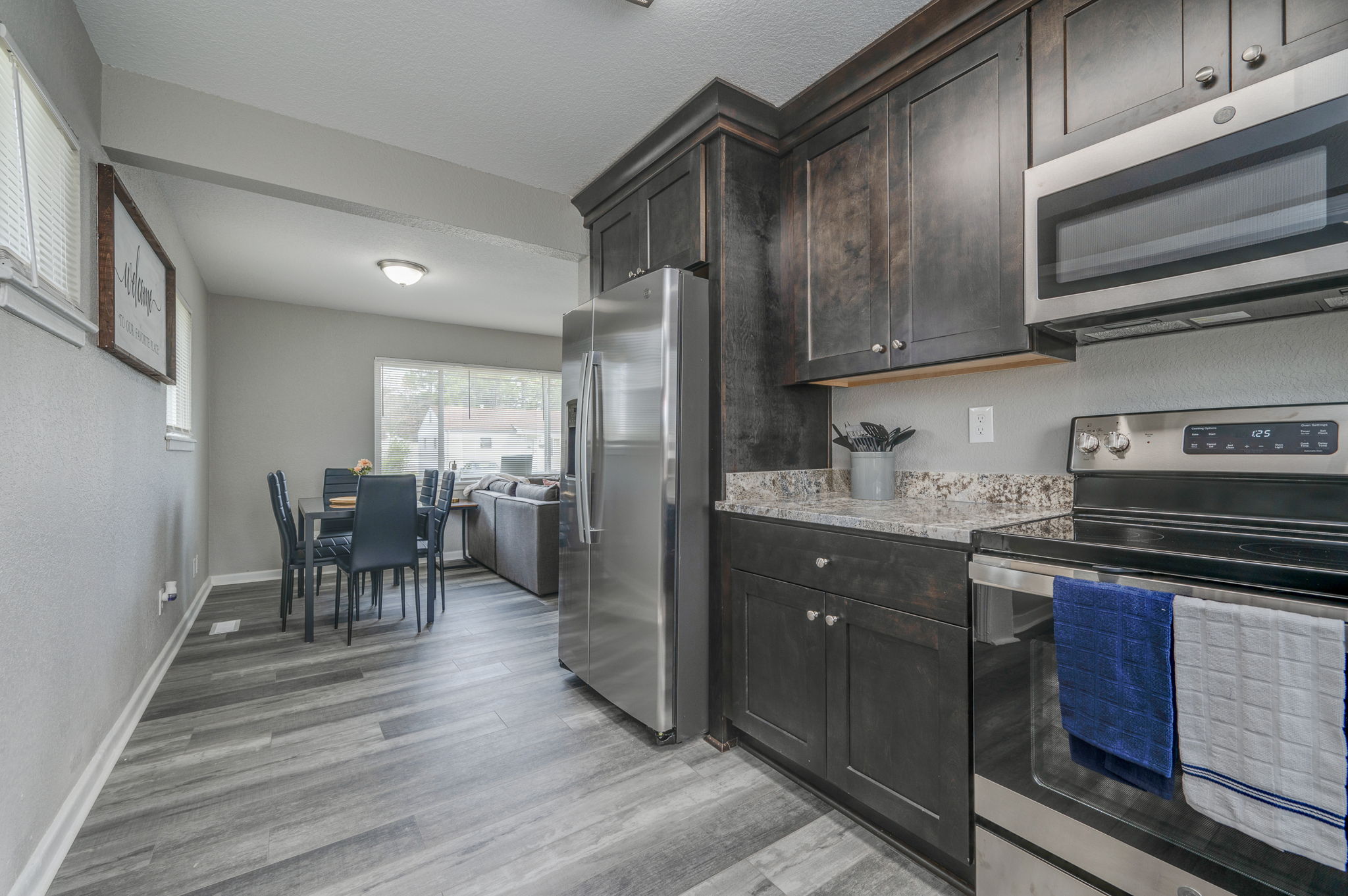 Open-concept kitchen with stainless steel refrigerator and dining area