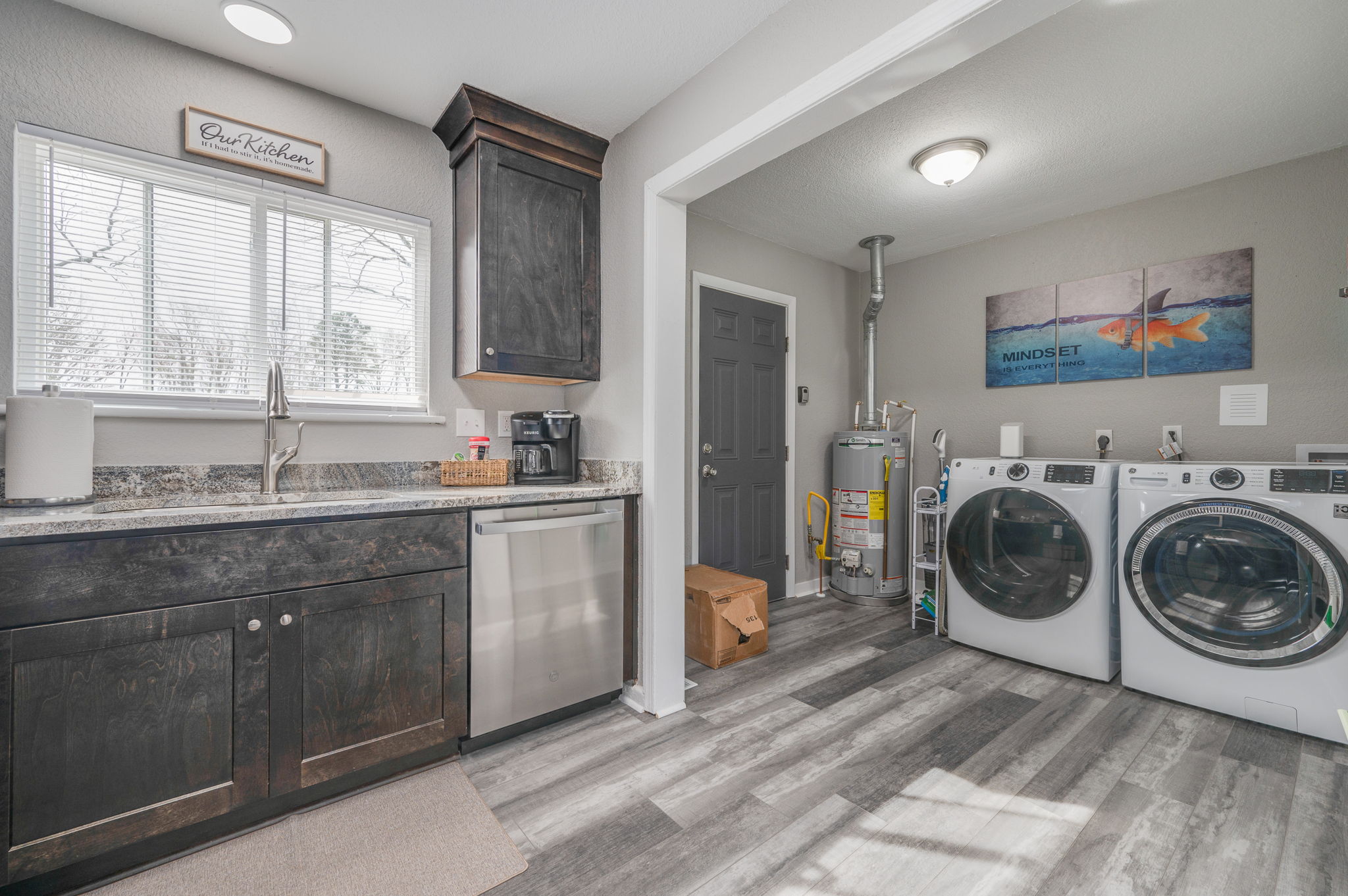 Kitchen with dark wood cabinets leading into a laundry area