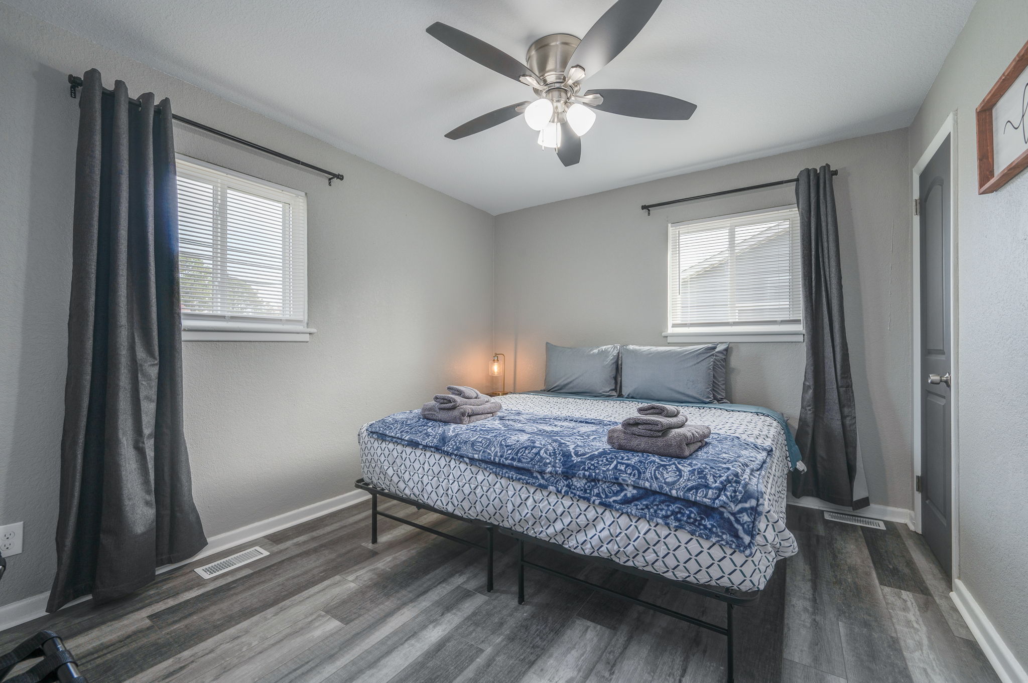 Bedroom with a king-size bed, blue bedding, and natural lighting