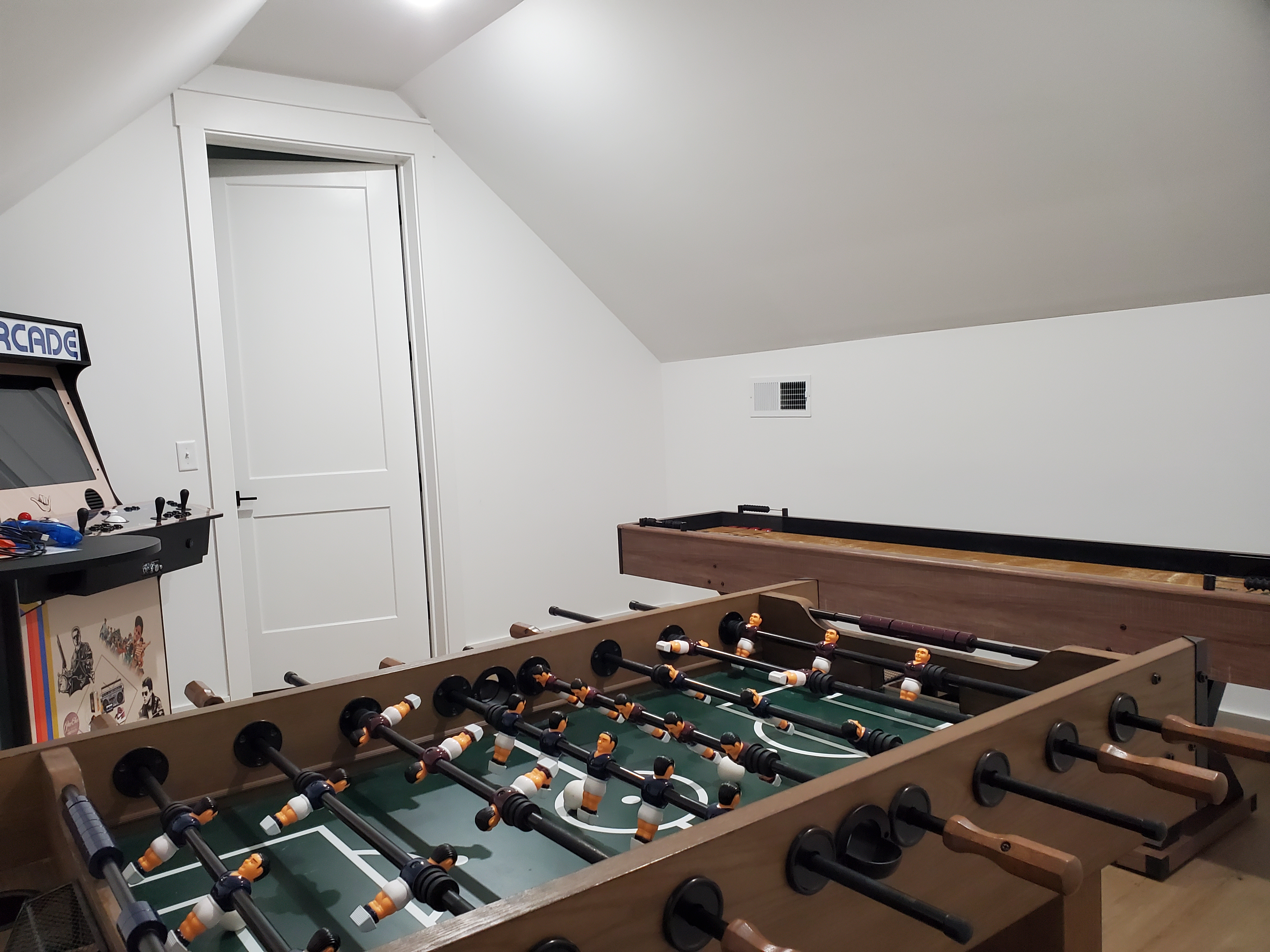 Recreational room with foosball, shuffleboard, and arcade games
