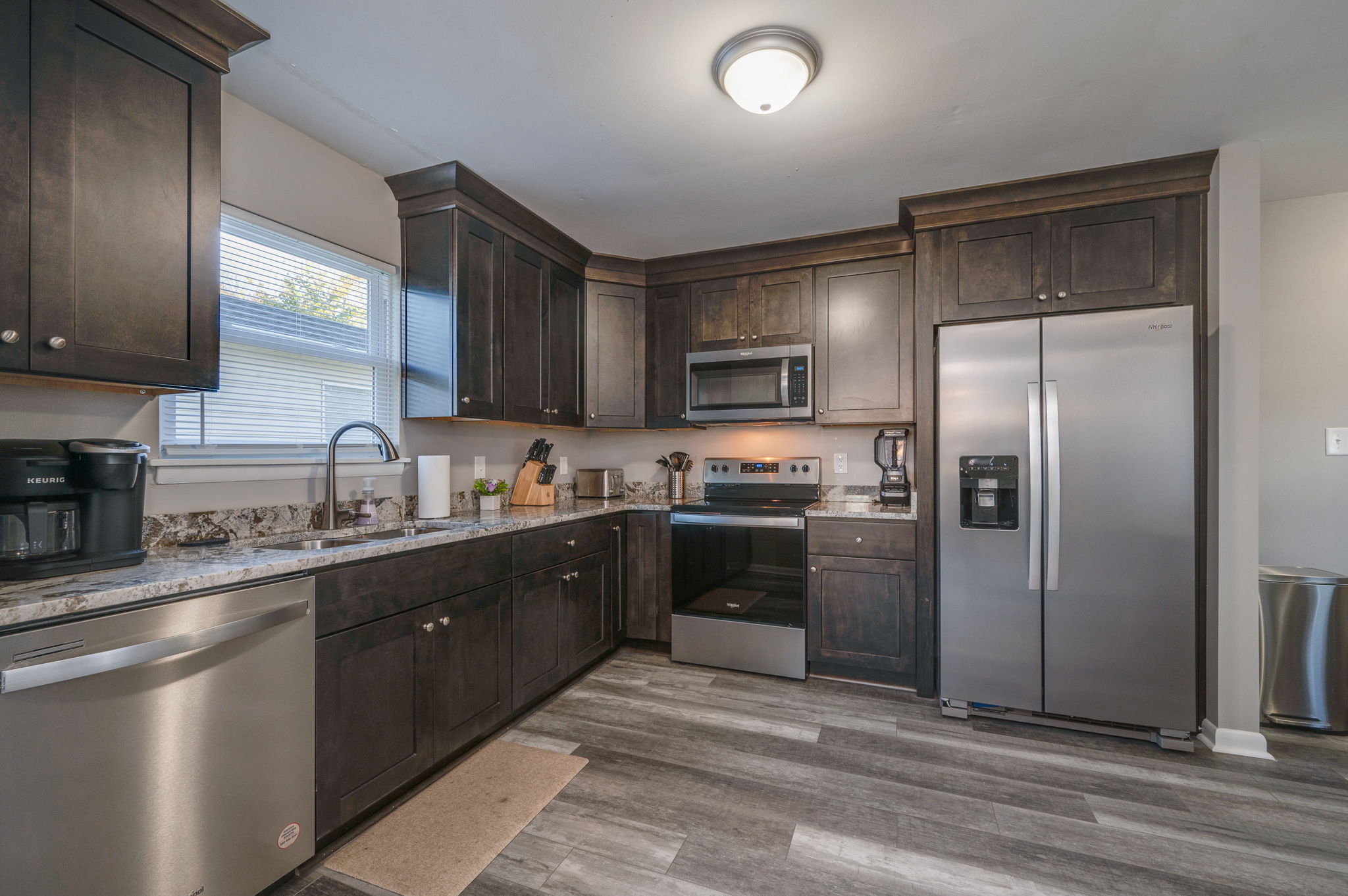 Kitchen with dark wood cabinets, stainless steel appliances, and granite countertops.